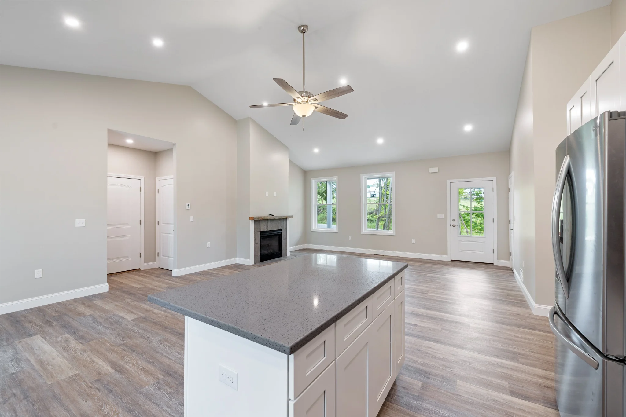 Bright open-plan remodeled kitchen and living area with an island and fireplace