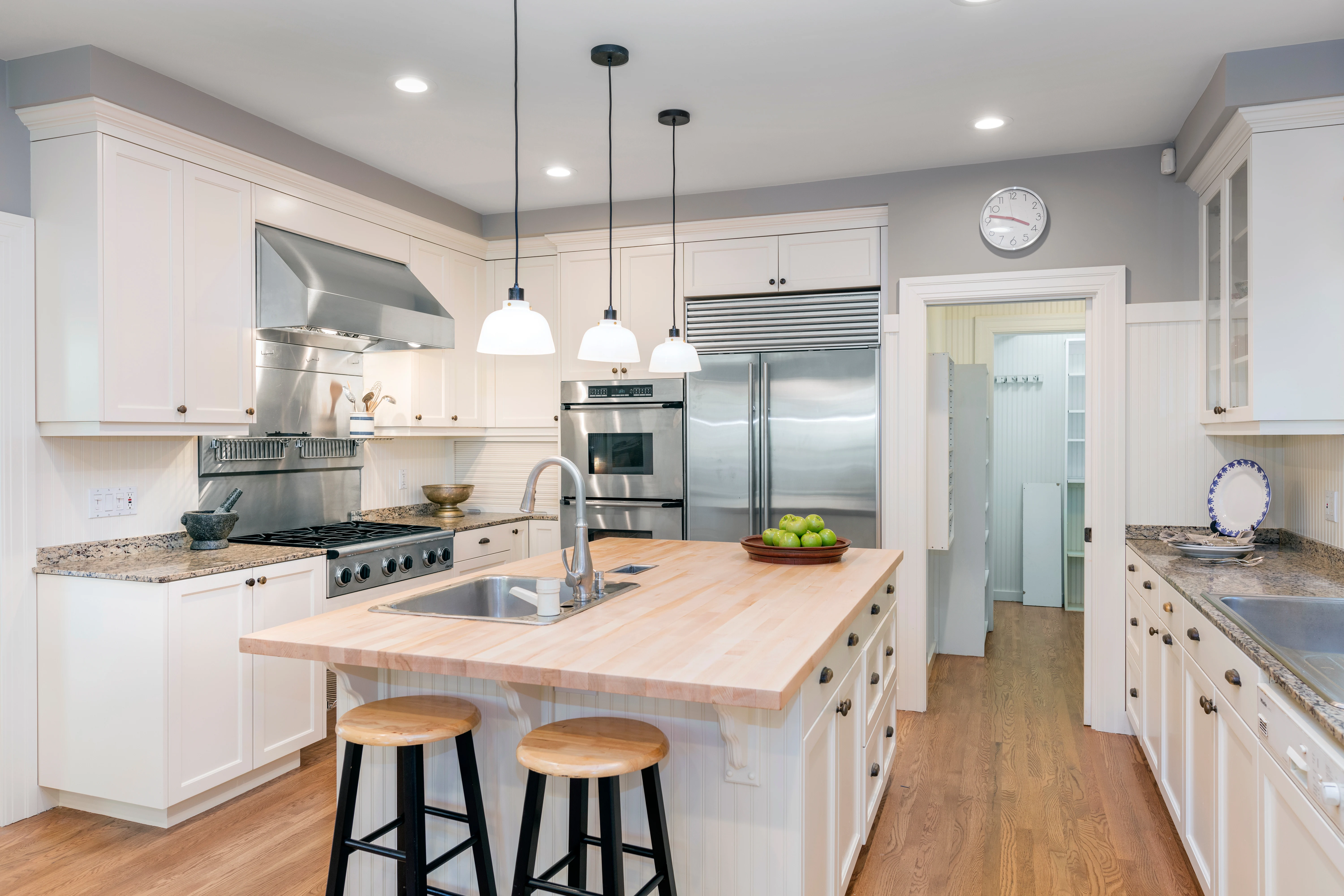 White kitchen remodel with an island and wood flooring